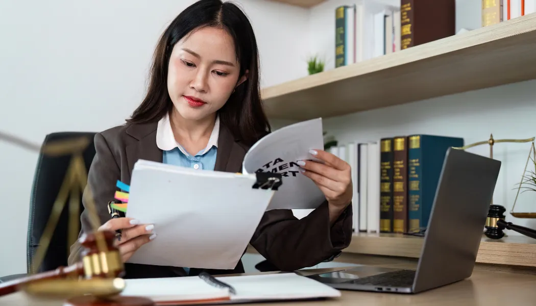 Femme qui lit des documents juridiques à son bureau