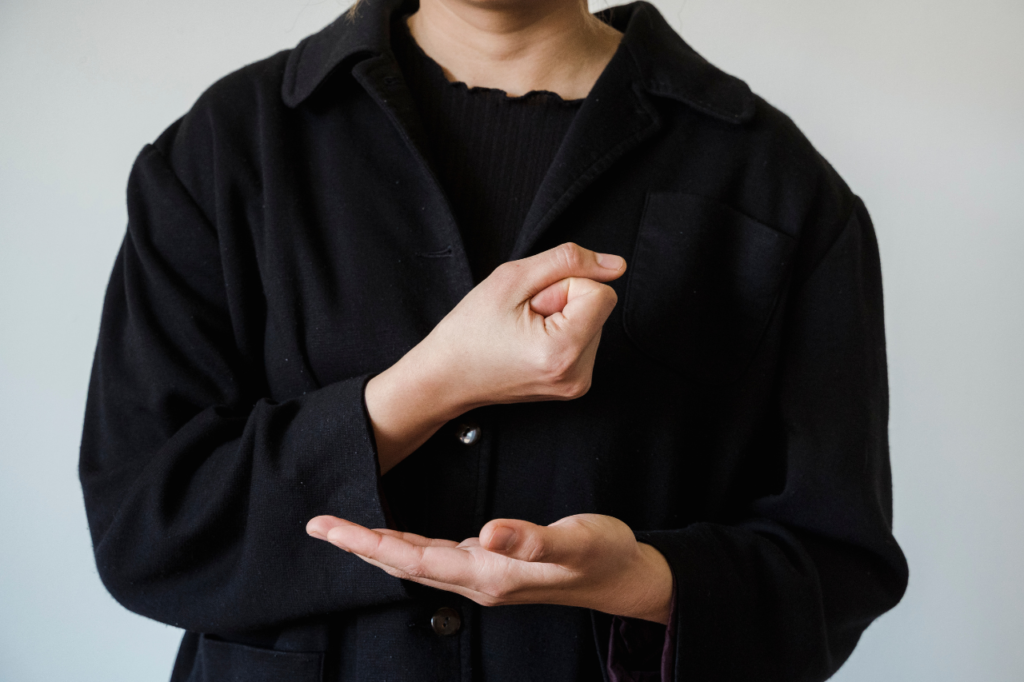 personne avec une chemise noir qui parle en langue des signes